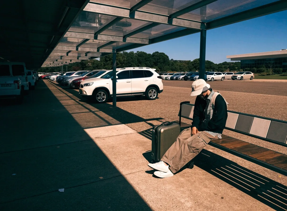 Budget parking lot near Brisbane Airport with shuttle shelter and parked cars